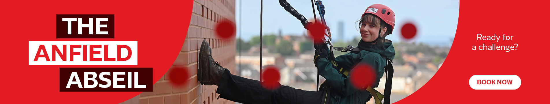 Red graphic background with white lettering ‘THE ANFIELD ABSEIL’. An abseiler graphic and stadium wall in view behind. 