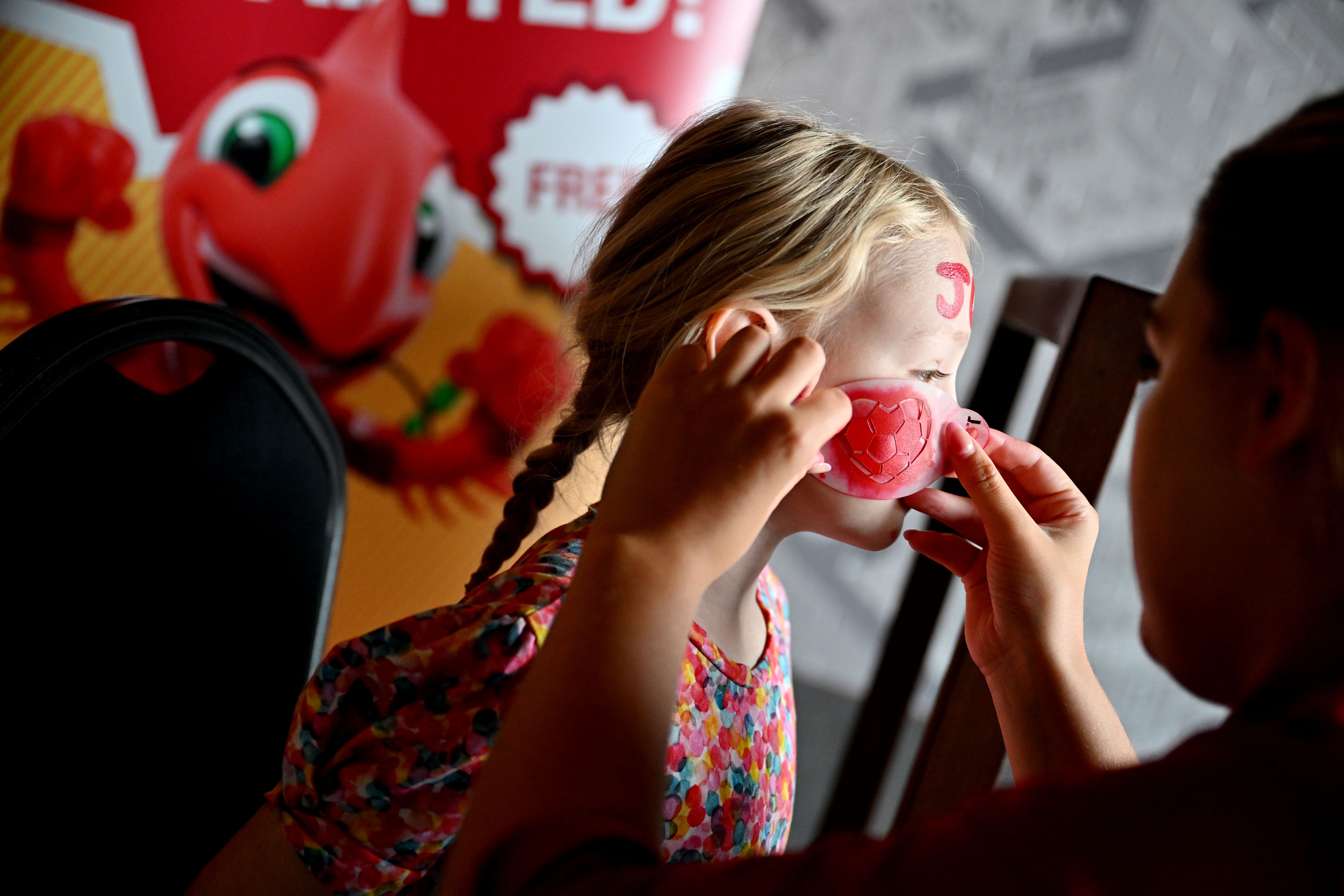 A young fan getting her face painted
